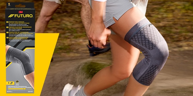 Coureur sur un sentier portant un manchon de compression premium pour genou FUTURO, avec l’emballage du produit visible
